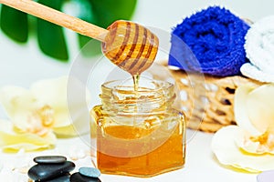 Gold honey in a jar, orchid flowers, towels and scented candles