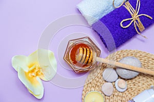 Gold honey in a jar, orchid flowers, towels and scented candles