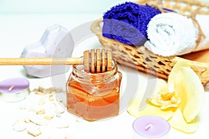 Gold honey in a jar, orchid flowers, towels and scented candles