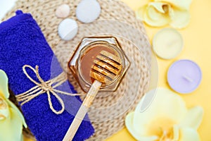 Gold honey in a jar, orchid flowers, towels and scented candles