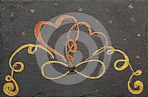 Gold infinity symbol and two hearts painted on a slate, evelasting, expansion love