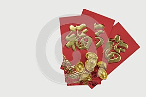 Gold ingots and Traditional Chinese angpow on red cloth.