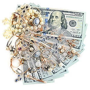 Gold jewelry and dollars on white background.