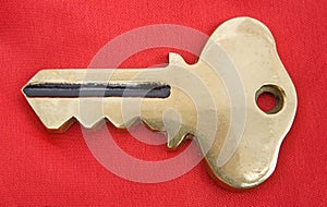 Gold key on red.