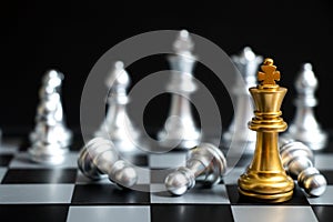 Gold King in chess game face with the silver team on black background Concept for company strategy, business victory or