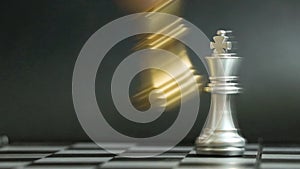 Gold king chess piece knock and win over silver team on black background Concept for company strategy, business victory