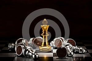 Gold king chess surrounded by a number of fallen silver chess pi