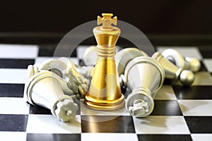 gold King chess surrounded by a number of fallen silver chess pieces , business strategy concept