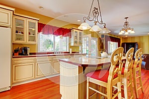 Gold kitchen with white antique cabinets.