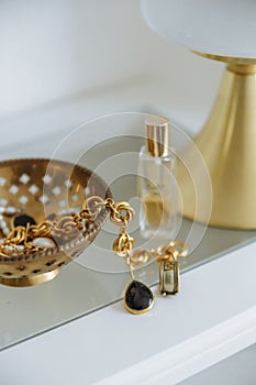 Gold lapm gold accessories jewelry white table in cozy interior