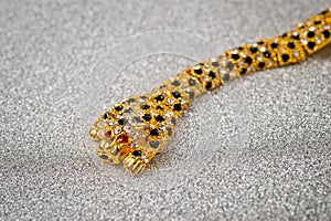 Gold leopard bracelet with shiny pebbles, lepard eyes made of bright red stones