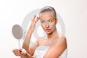 Gold make up. Brown sleek hair beautiful woman looking at mirror