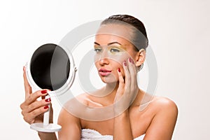 Gold make up. Brown sleek hair beautiful woman looking at mirror