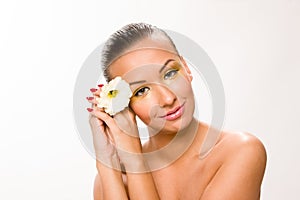 Gold make up. Brown sleek hair beautiful woman with white flower