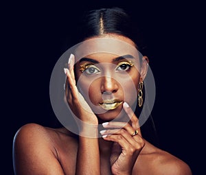 Gold makeup, serious and portrait of a woman isolated on a black background in a studio. Beauty, young and glamorous