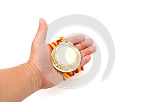 Gold medal on males hand on white background