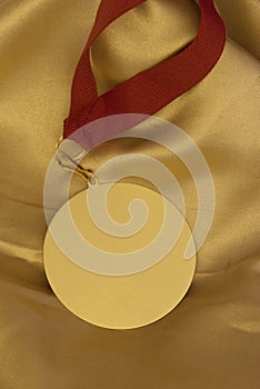 Gold medal on shiny golden cloth