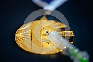 Gold medal and syringe. Doping and drugs in sport, concept photo. Black background