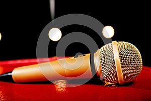 Gold microphone on dark background with many lights