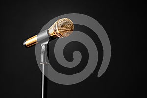 Gold microphone on stage on a black background