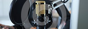 Gold modern professional studio microphone closeup background