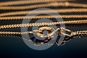 Gold necklace chain clasp or closure closed on reflecting glass table