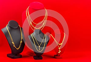 The Gold necklaces on red and black color necklace display stand