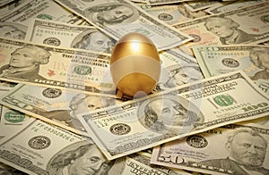 Gold nest egg on a layer of cash photo