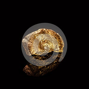 Gold nugget on black background.