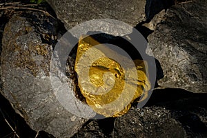 Gold nugget and grey granite stone background