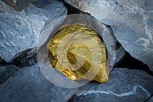 Gold nugget and grey granite stone background