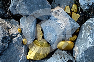 Gold nugget and grey granite stone background