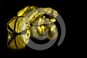 Gold nuggets on black background with reflection