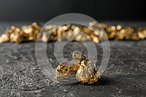 Gold nuggets on dark table photo