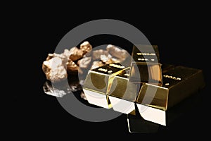 Gold nuggets and ingots on black