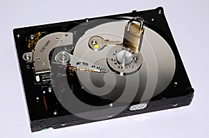 Gold padlock on the opened HDD disk drive surface. Data protection or security concept.