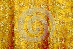 Gold peach lace sits on a gold silk background