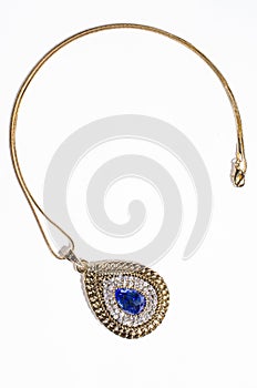 Gold pendant with blue gem on a white background