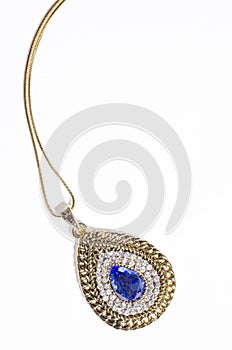 Gold pendant with blue gem on a white background