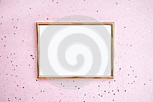 Gold photo frame, pink background with sparkles. Flat lat. Top view. Place for text