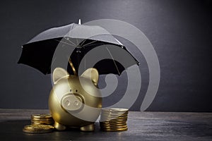 Gold Piggy bank with umbrella concept for finance insurance, protection, safe investment or banking