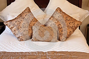 Gold pillows on white bed