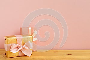 Gold and pink gift boxes on wooden table