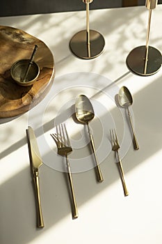 Gold plate. Cutlery set. Fork, spoon, knife, dessert fork, teaspoon. Fashion photo shoot.