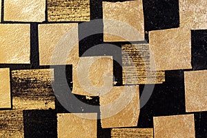 Gold plate on wall black, gold leaf, golden square foil on black background, black tile wall with gold plate abstract texture