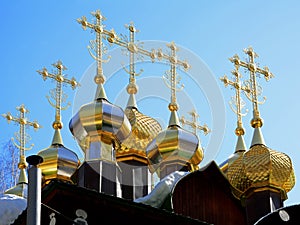Gold-plated domes with crosses of wooden Russian Orthodox Christian Church of St. Nicholas in Ganina Yama Monastery.