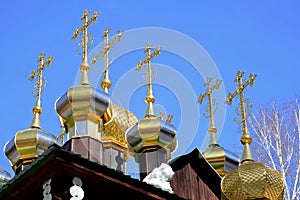 Gold-plated domes with crosses of wooden Russian Orthodox Christian Church of St. Nicholas in Ganina Yama Monastery.