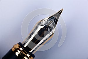 Gold plated fountain pen closeup on a grey background