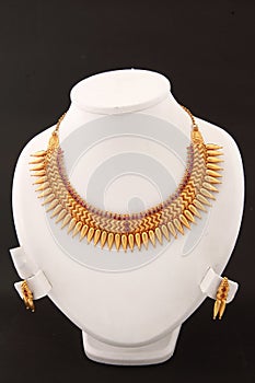 gold-plated stone-studded short necklace, with three strands with pink diamonds.