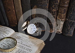 Gold pocket watch Pavel Bure on a gold pendant. Royal Russia. pocket watch on a dark background with books.